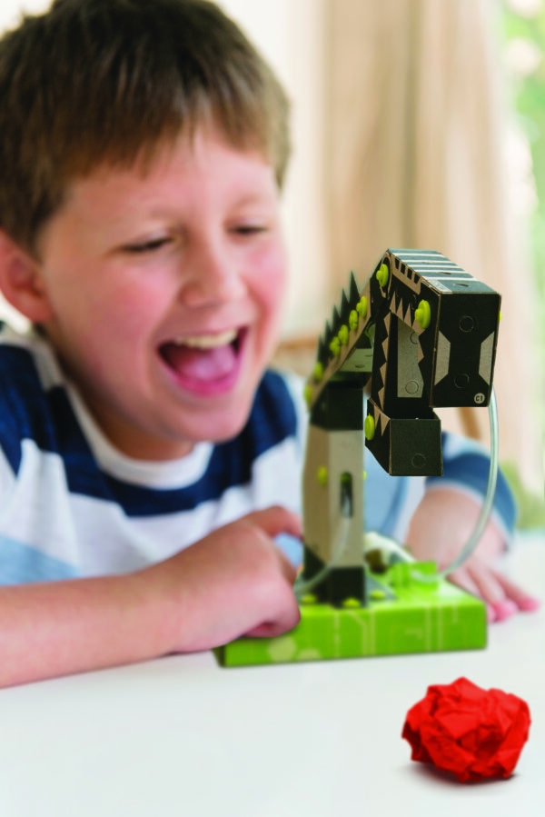 Happy child playing with the finished product from our 4M TechCraft Paper Science Robot Arm